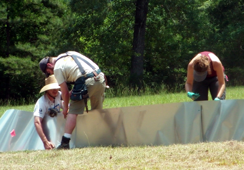 Chris, Travis, and Nicole installing flashing to build the enclosures